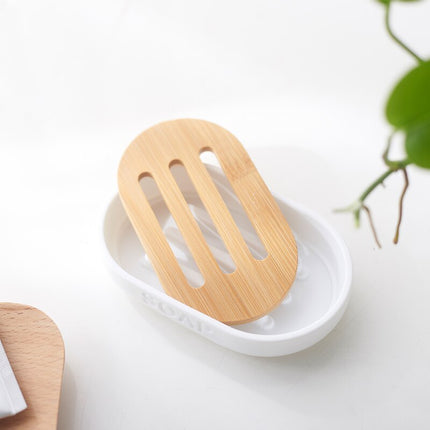 Valkoinen soikea saippua-alusta puuritilällä