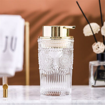 Lasinen saippua-annostelija kultaisella pumpulla