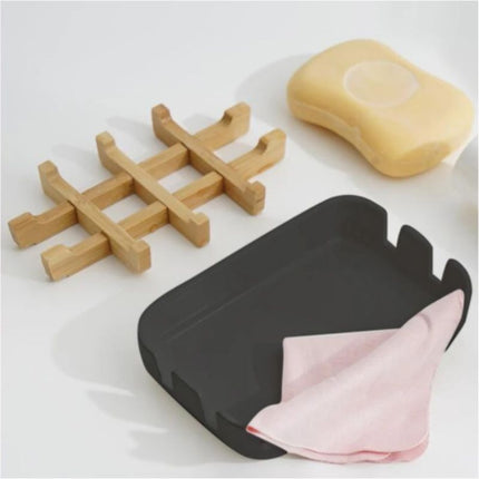 Musta saippuateline puisella bamburitilällä