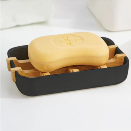 Musta saippuateline puisella bamburitilällä